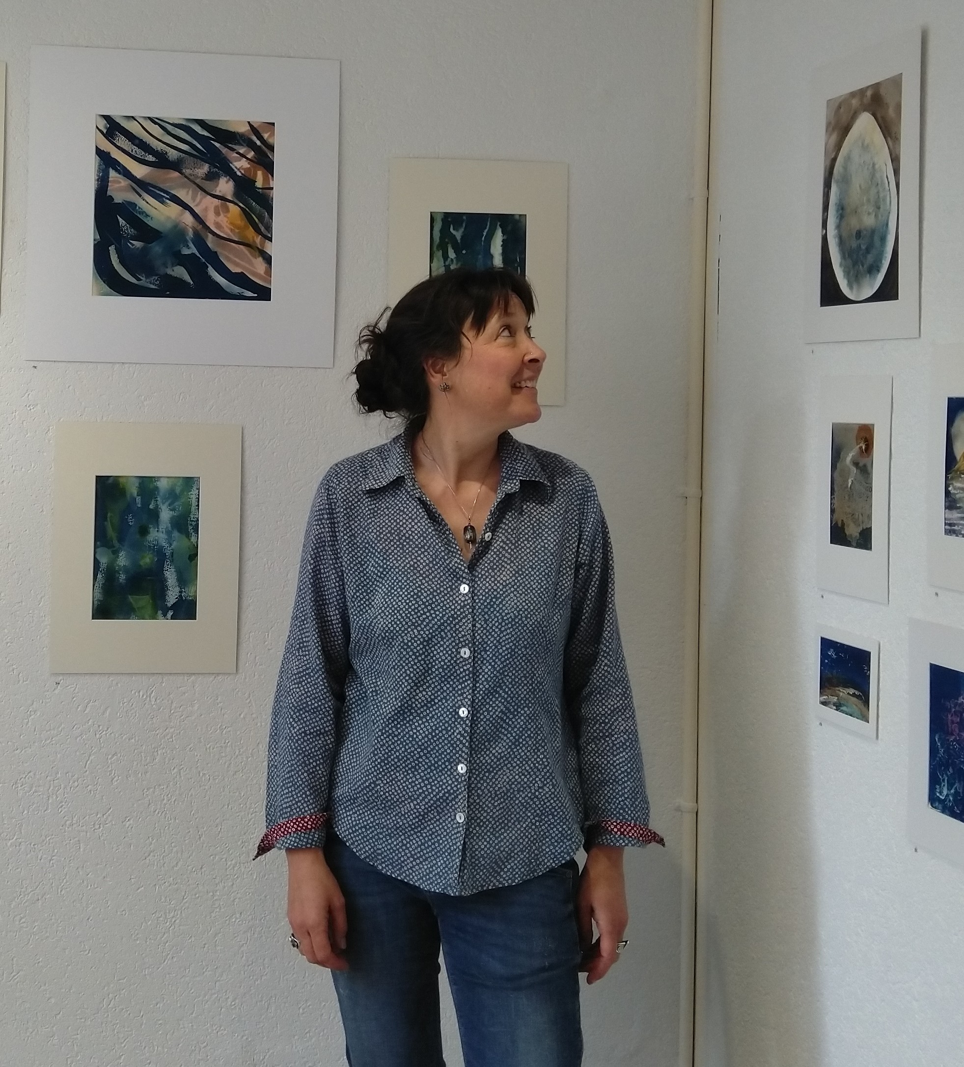 Sarah Stékoffer, médiatrice en expression artistique chez Mousse qui Roule à Delémont, debout devant des œuvres d’art.